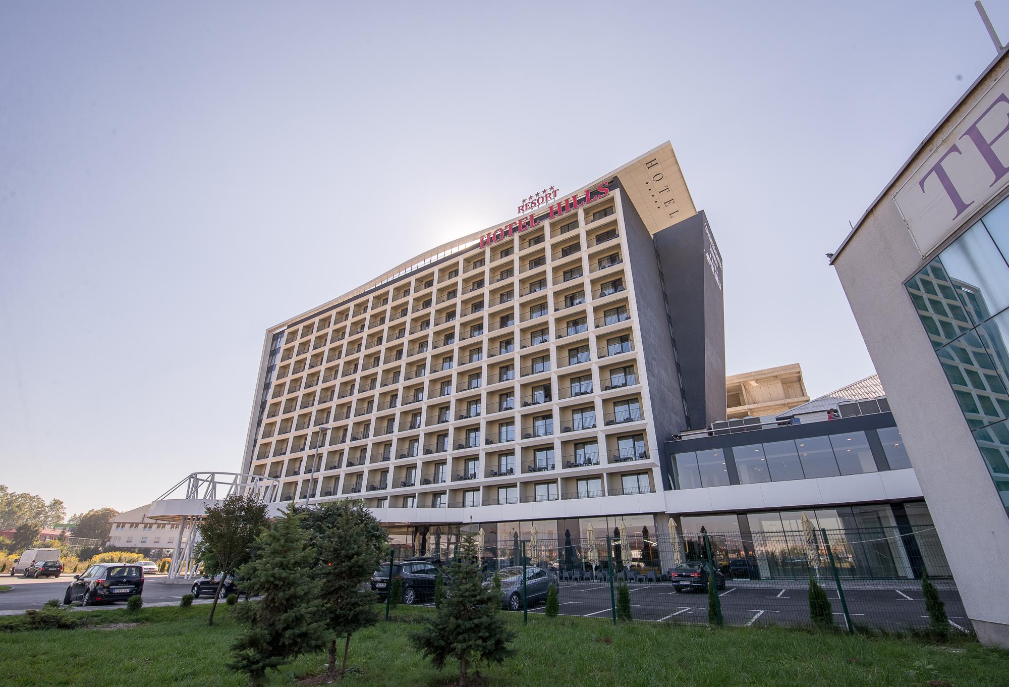 Hotel Hills Sarajevo Congress & Thermal Spa Resort Ilidža Exterior foto The photo shows a modern hotel building with multiple floors and a contemporary design. The structure features large windows arranged in a grid pattern and a prominent entrance area at the bottom. There are green areas, possibly with trees or landsca